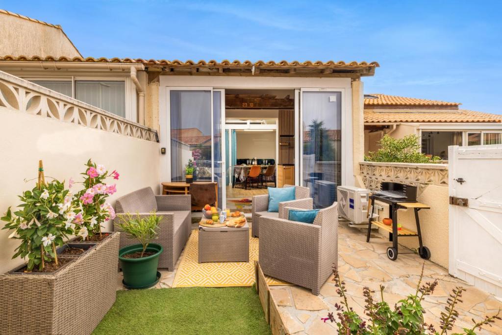 une terrasse arrière avec des chaises et une table dans l'établissement La Maison du Plaisir, à Gruissan