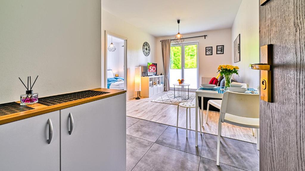a kitchen and a living room with a dining room at Apartament Pod Brzozami - 5D Apartments in Świeradów-Zdrój