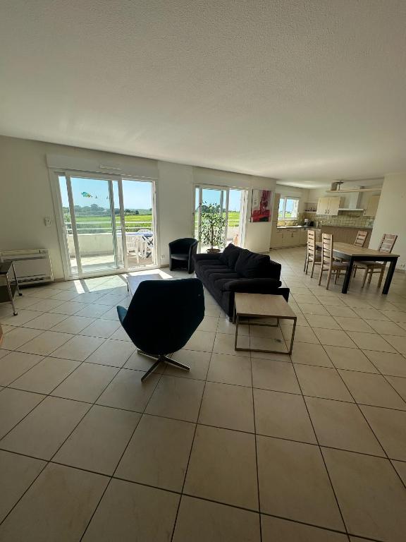 un salon avec un canapé et une table dans l'établissement Appartement vue mer avec garage, à Aytré