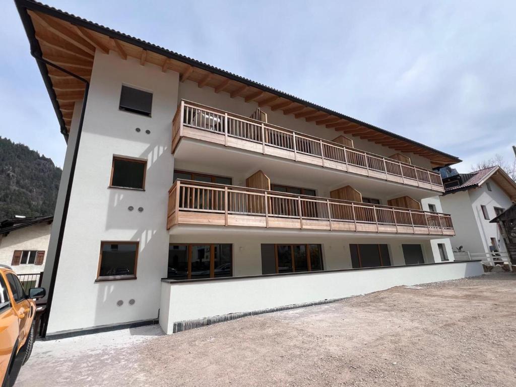 ein weißes Gebäude mit einem Balkon auf der Seite in der Unterkunft Villa Fontane in Truden