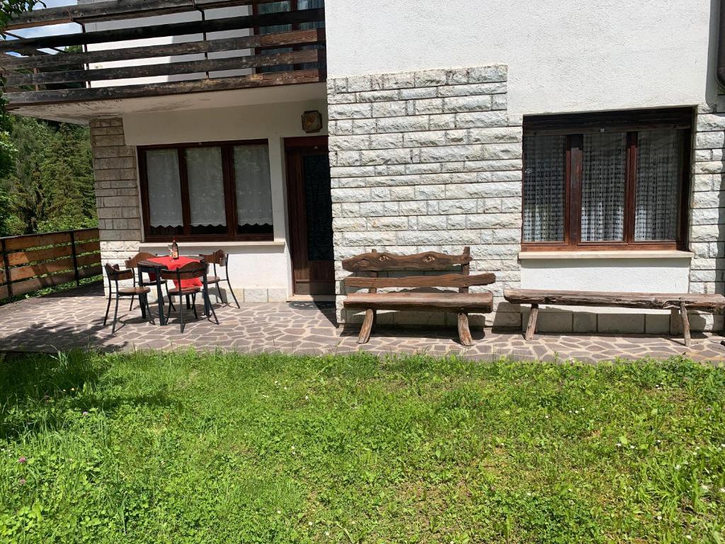 a patio with a table and chairs and a bench at Casa Bruna in Forno di Zoldo