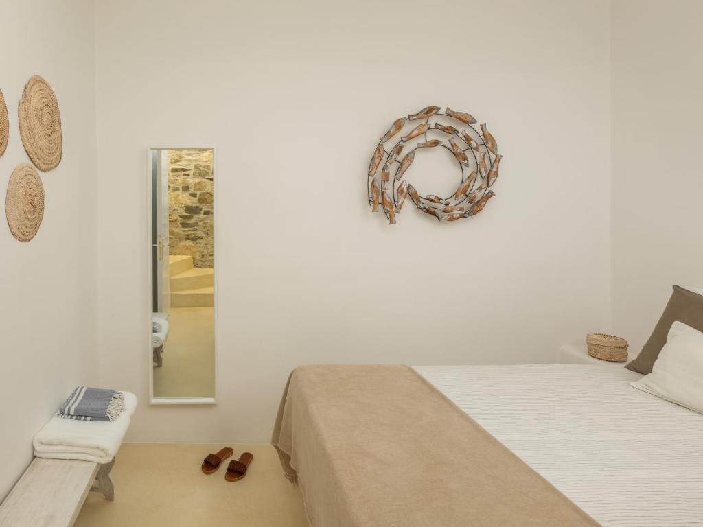 a bedroom with a bed and a wreath on the wall at Serifos Dream Houses near the sea in Ganema