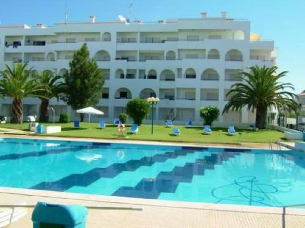 a large swimming pool in front of a building at Quinta das Palmeiras - T2 in Porches