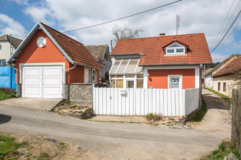 una casa roja con una valla blanca en Chalupa Hanička, en Štěměchy