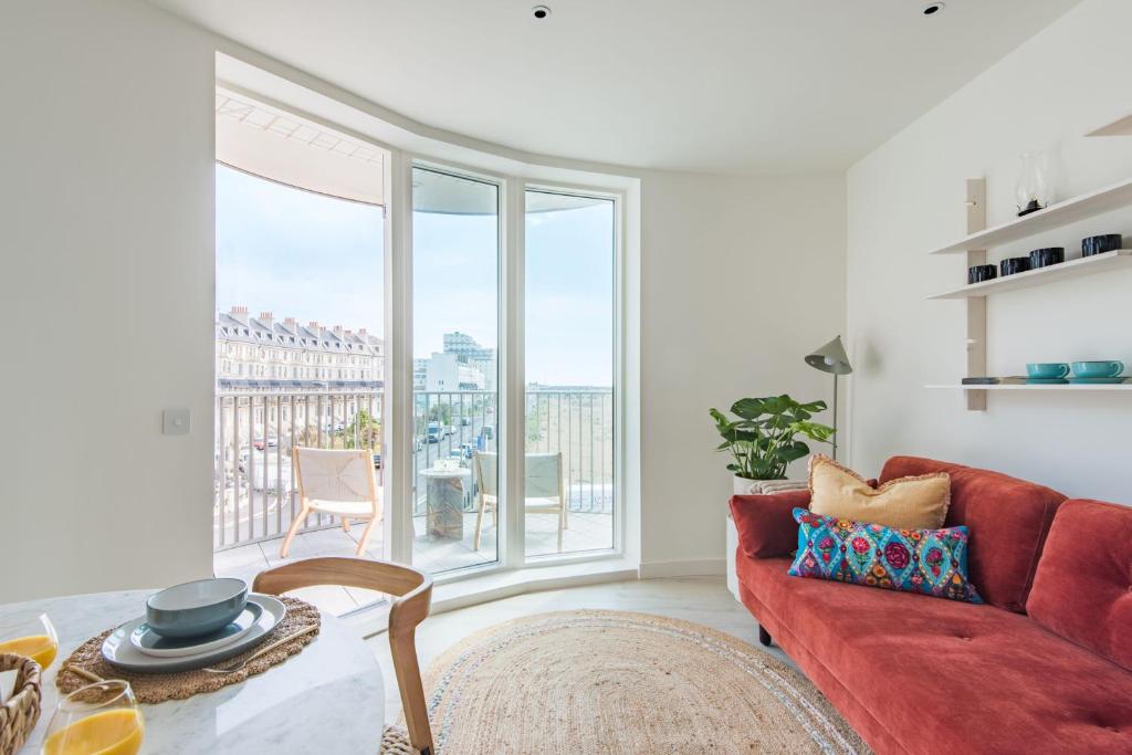 ein Wohnzimmer mit einem roten Sofa und einem großen Fenster in der Unterkunft The Perch at Shoreline in Folkestone