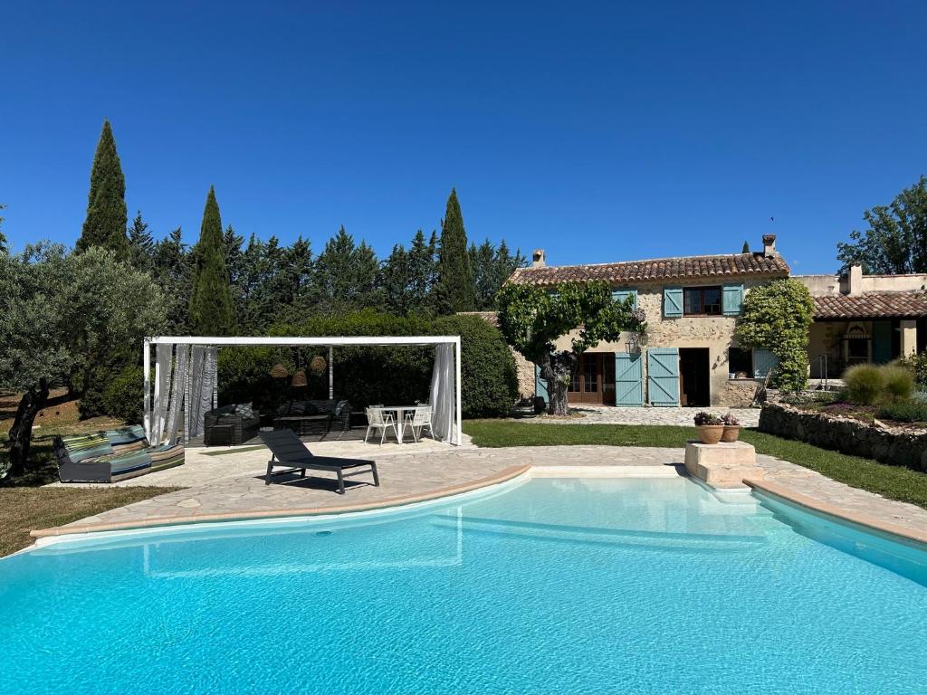- une piscine avec une chaise à côté d'une maison dans l'établissement Villa Libellule, à Cotignac