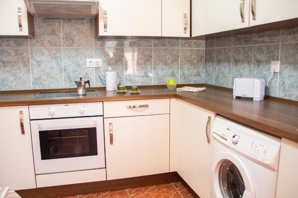 a kitchen with white cabinets and a washer at TAO El Cotillo in El Cotillo