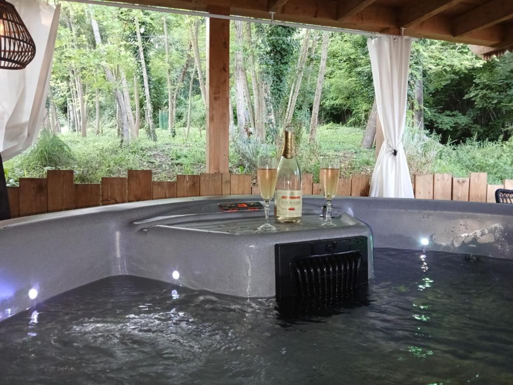 - une baignoire remplie d'eau avec deux verres de vin dans l'établissement La Maison Pas'Chaaxe, à Onzain