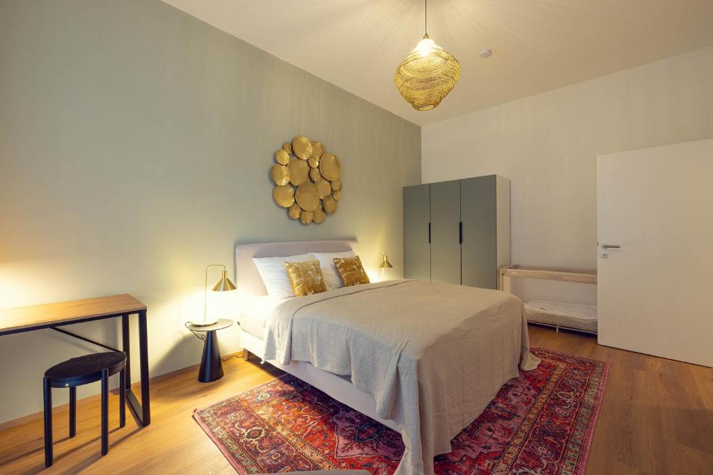 a bedroom with a bed and a table and a rug at LeonArt Living 12 in Graz