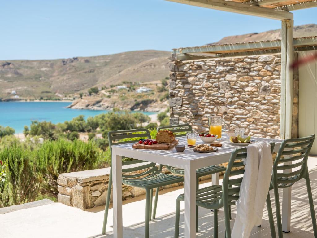 a table and chairs on a patio with a view of the water at Serifos Dream Houses near the sea in Ganema