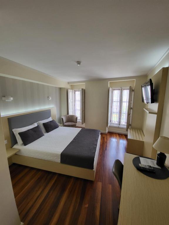 a bedroom with a large bed and a television at Hotel Residencial Dora in Braga