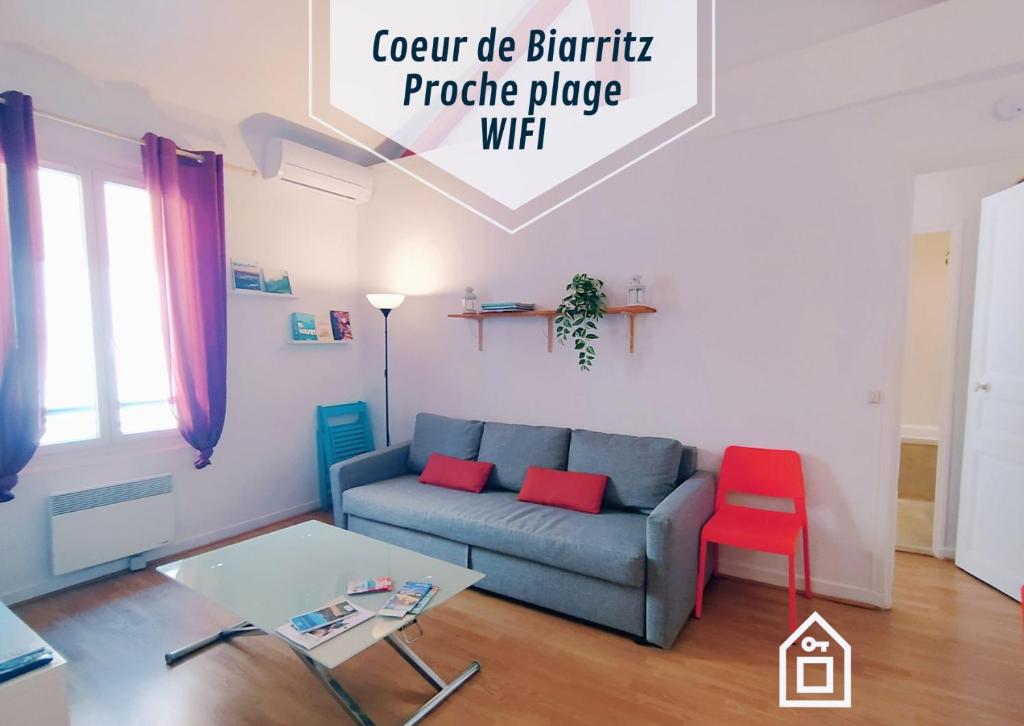 - un salon avec un canapé bleu et un fauteuil rouge dans l'établissement Mounette Etxea, à Biarritz