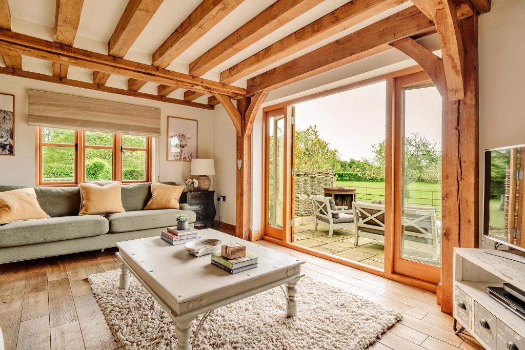 a living room with a couch and a table at Finest Retreats - Windfall Cottage in Tewkesbury