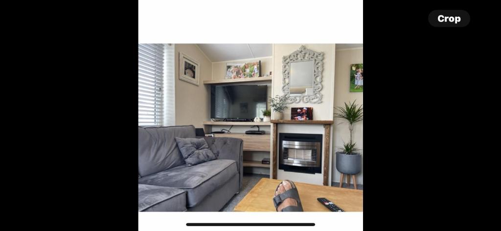 a living room with a couch and a tv at Haven Holiday Park Orchards in Saint Osyth