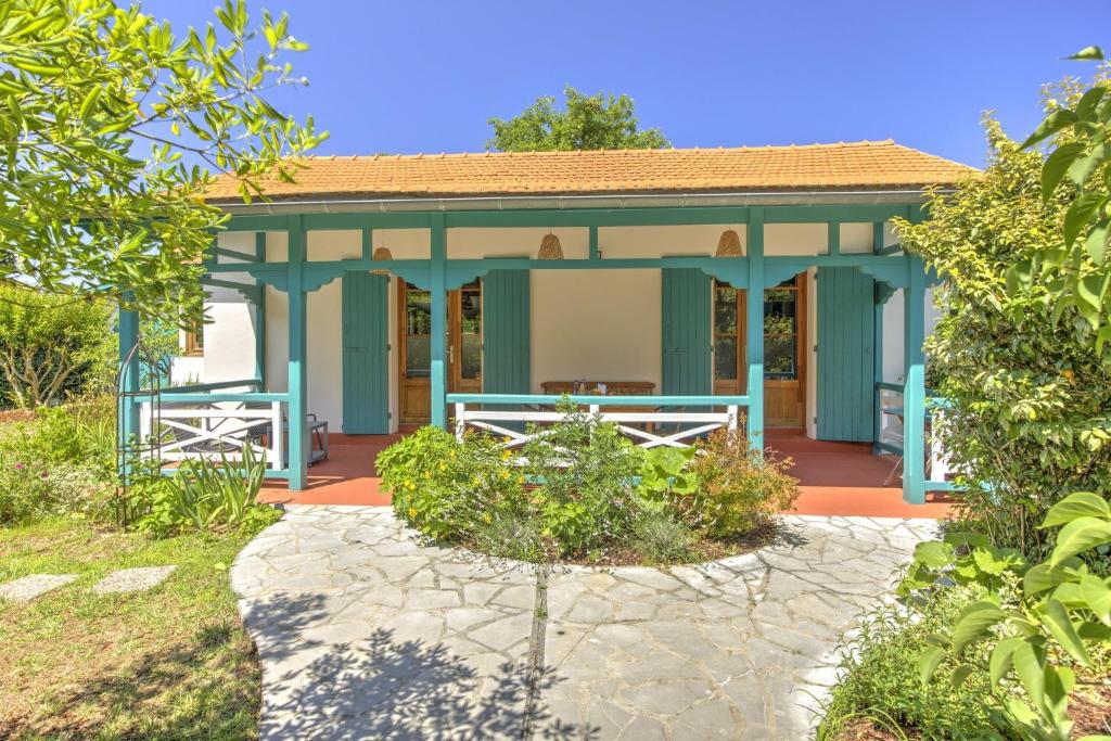une maison bleue avec un jardin en face dans l'établissement La Maison des Lilas - Proche du bassin, à Gujan-Mestras