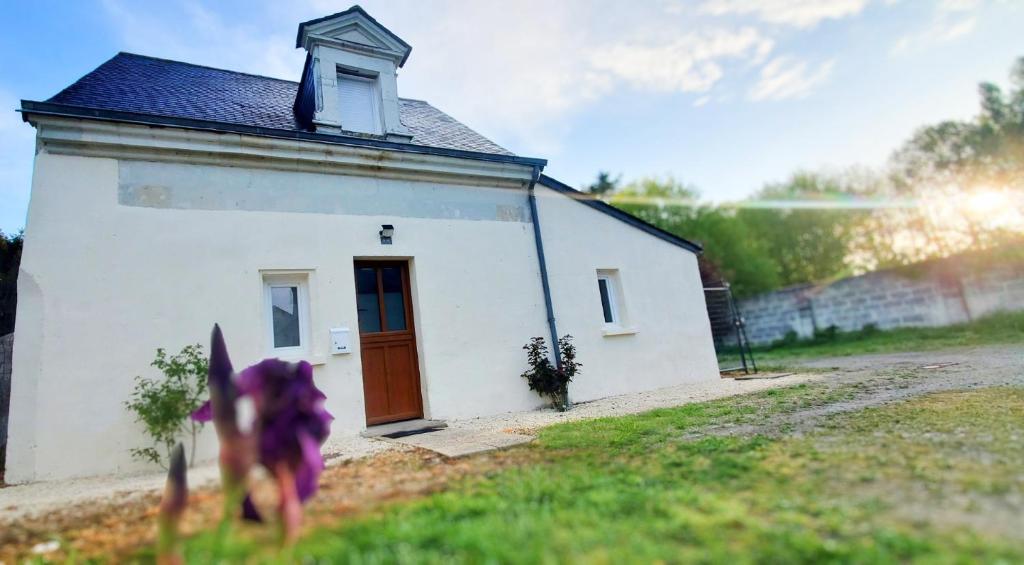 a small white building with a red door at Gîte AnjouLoire in Saint-Mathurin