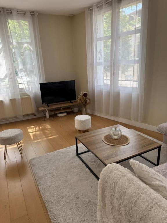 un salon avec une table basse et une télévision dans l'établissement Espace détente ou de travail à 1h de Paris, à Mantes-la-Jolie