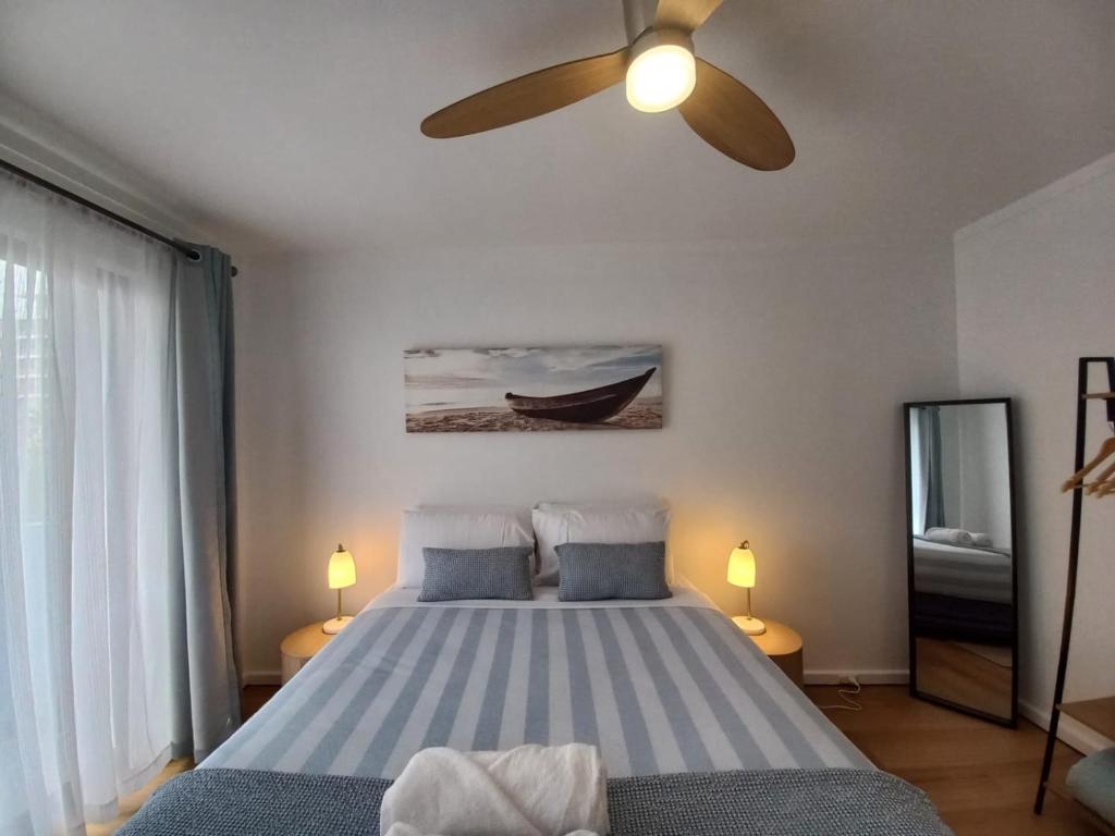une chambre avec un lit avec un ventilateur de plafond dans l'établissement NEW Coastal Salty Life - 2 bed 1st Floor, à Perth