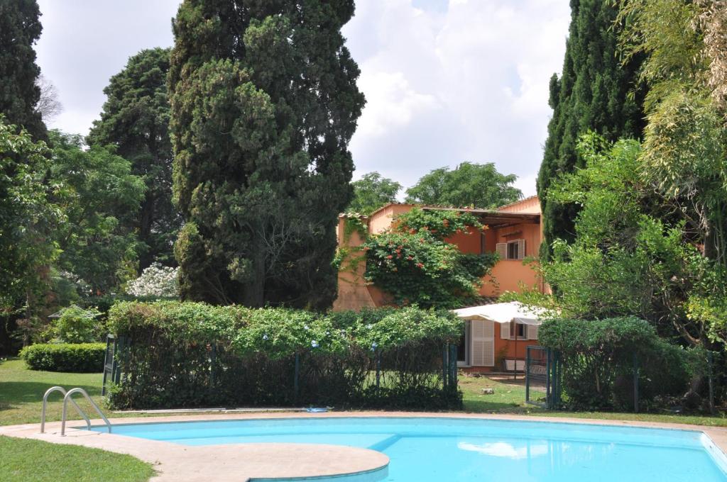 a swimming pool in front of a house with trees at Luxury Villa - Appia Antica in Rome