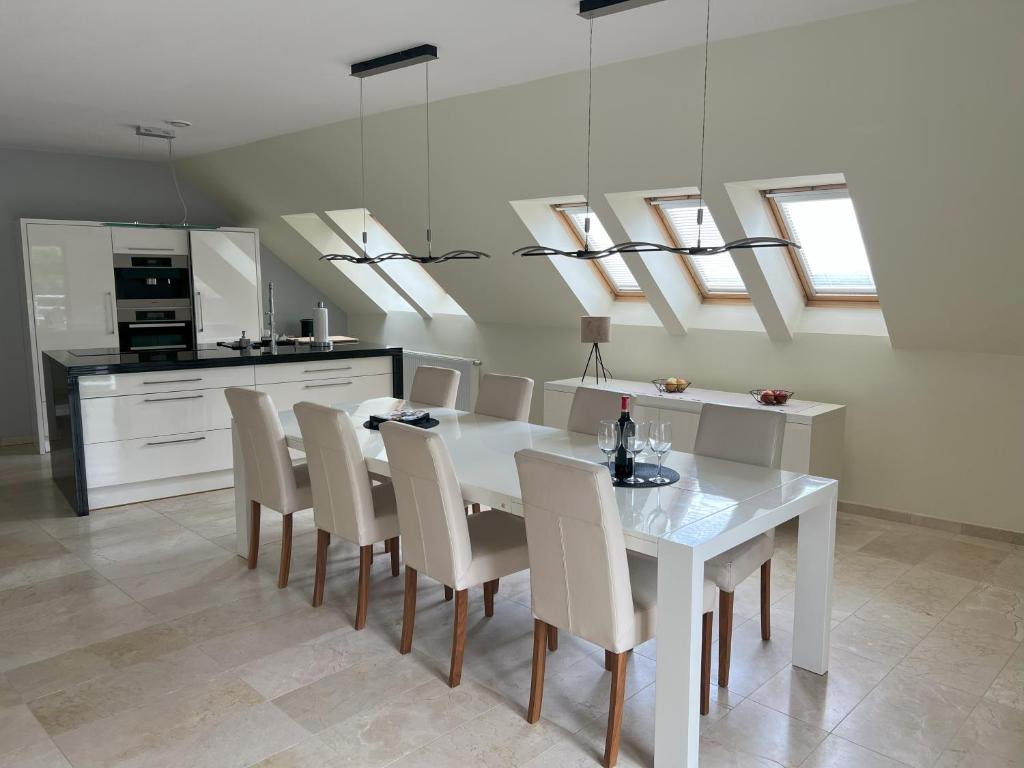 a kitchen and dining room with a white table and chairs at Szara Willa U Ksawerego in Szklarska Poręba