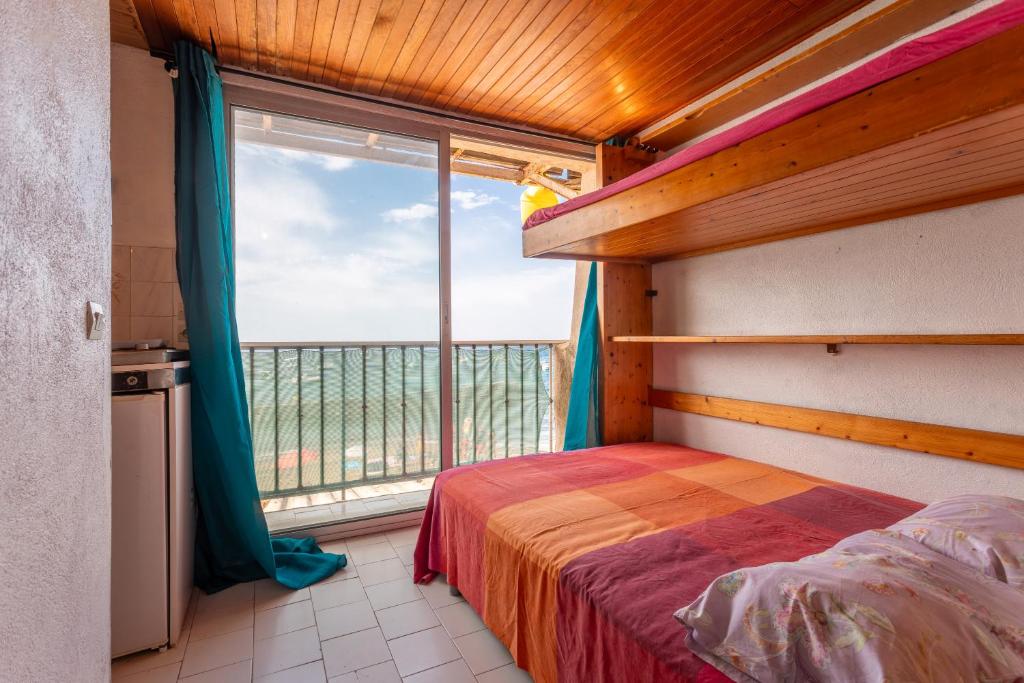 une chambre avec un lit et une grande fenêtre dans l'établissement Porte Rouge 4, au Pradet