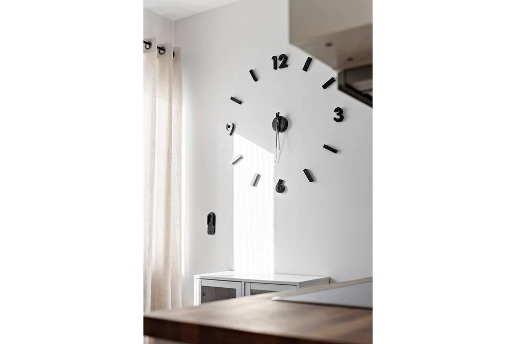 a clock hanging on a wall in a room at Apartament u Ann in Grzędzice