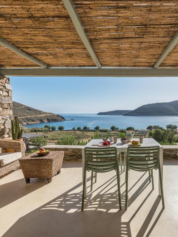 a table and chairs on a patio with a view of the ocean at Serifos Dream Houses near the sea in Ganema