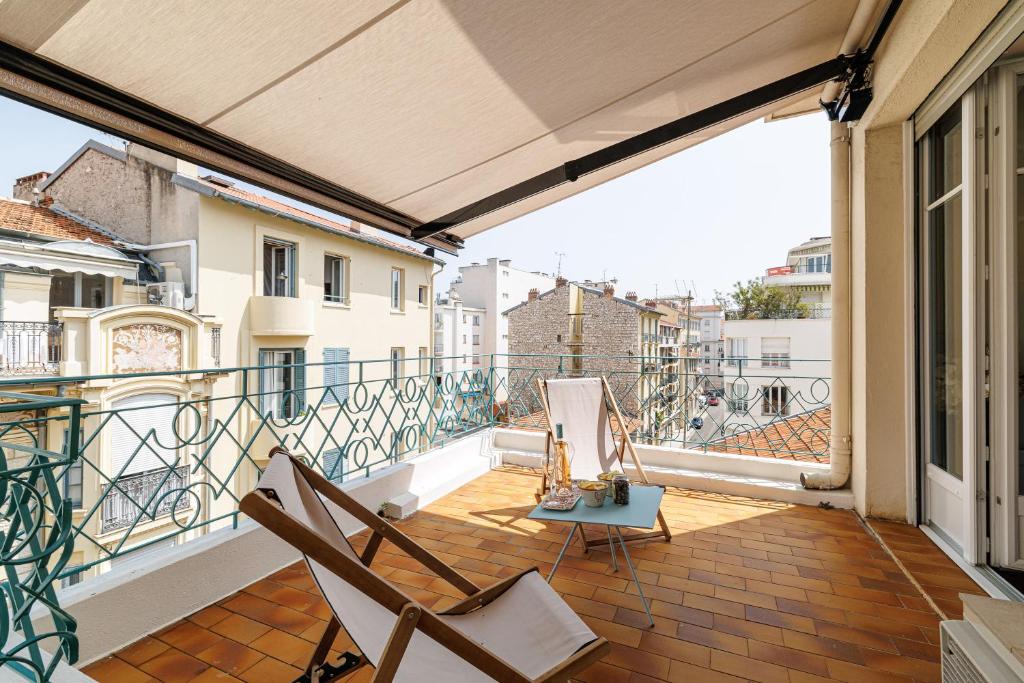 un balcon avec deux chaises et une table dans l'établissement Cosy Rooftop - Happy Rentals, à Nice