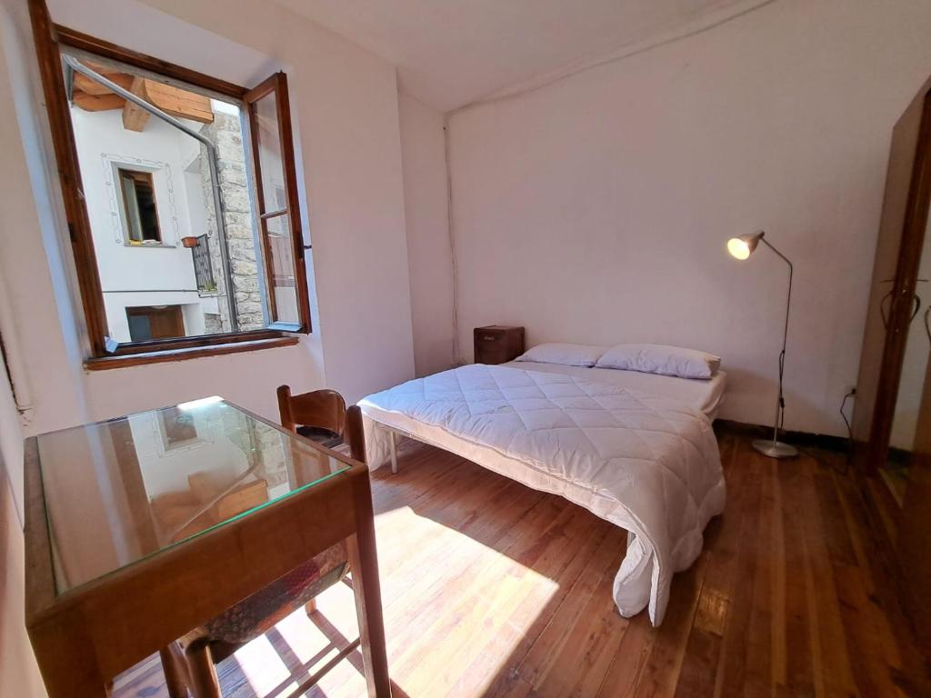 a bedroom with a bed and a glass table at GREEN DOLOMYTE Apartment in Schilpario