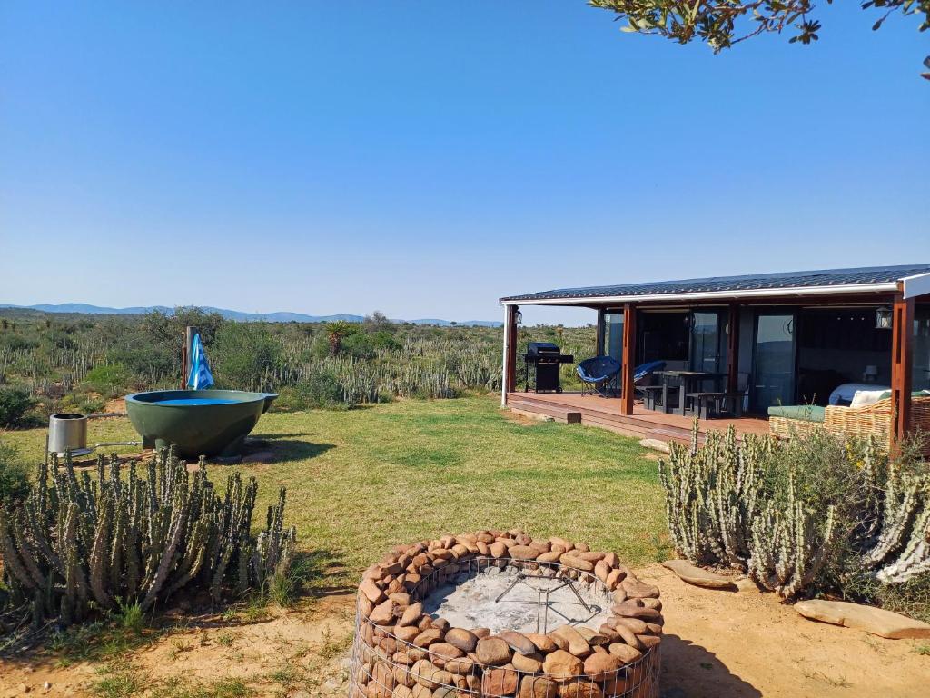 einen Hof mit einer Feuerstelle und einem Haus in der Unterkunft Lovedale Farm Getaway in Jansenville