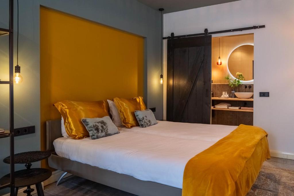 a bedroom with a large bed with yellow sheets at B and B Suite No.3 in Gorinchem