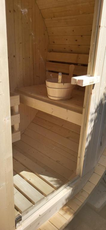 - un sauna en bois avec un bol au milieu dans l'établissement Gîte La Fabrique , spa et bain nordique, à Les Fontenelles