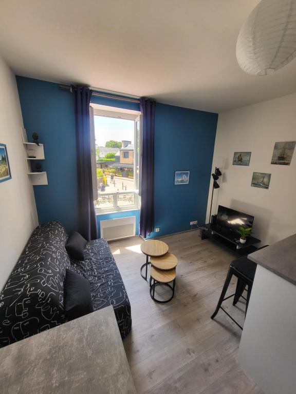 un salon avec un canapé et une table dans l'établissement Le Villageois, à Fouesnant