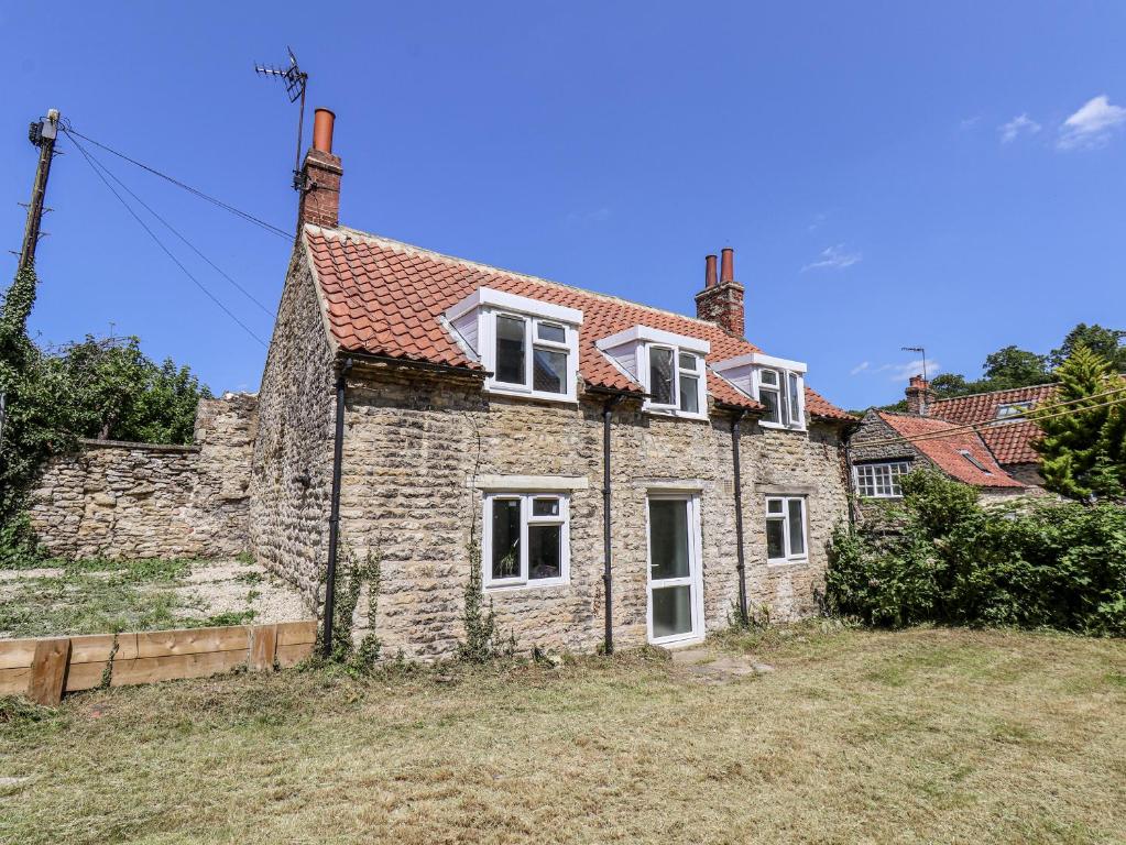 an old stone house with a red roof at Hemdin Cottage in Pickering