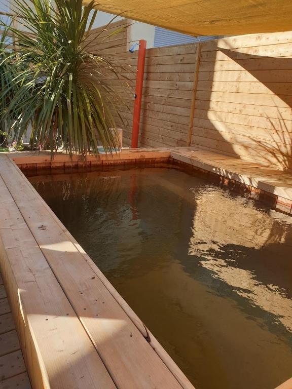 un bassin d'eau à côté d'une clôture en bois dans l'établissement Piscine, 3 chbs, terrasse, vue mer, à Palavas-les-Flots