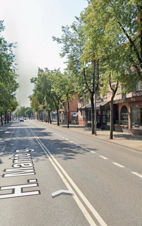 an empty street with trees on the side of the road at Manto Apartment in Klaipėda