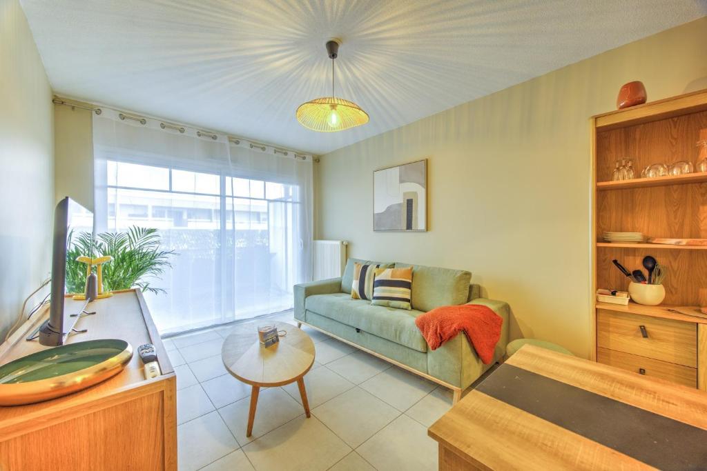 a living room with a couch and a table at Bonbini - 5min du Port de la Teste in La Teste-de-Buch