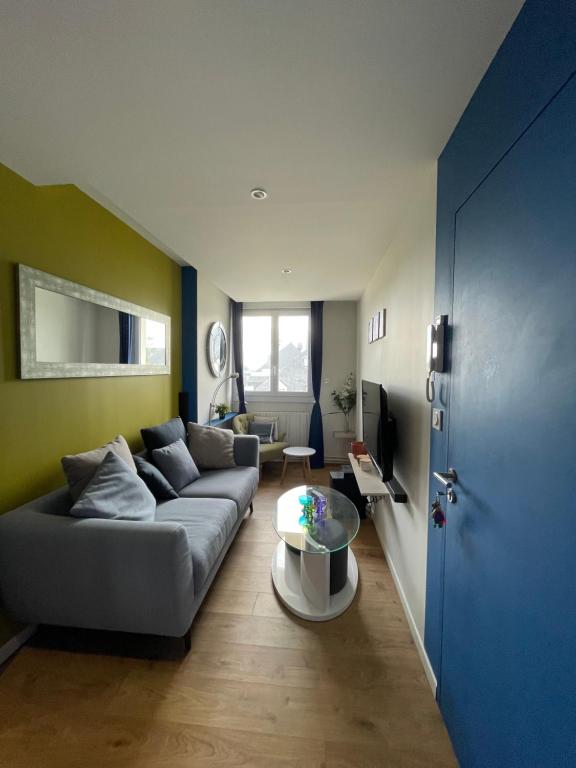 un salon avec un canapé et une table dans l'établissement Coliving Les Rosiers, à Laval