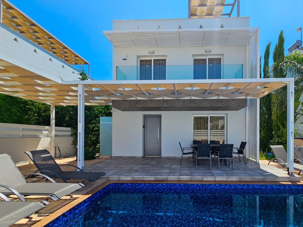a villa with a swimming pool and a house at Nissi beach villa Azure in Ayia Napa