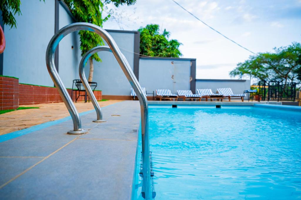 ein Schwimmbecken mit einem Metallgeländer im Wasser in der Unterkunft Greenside Hotel in Arusha