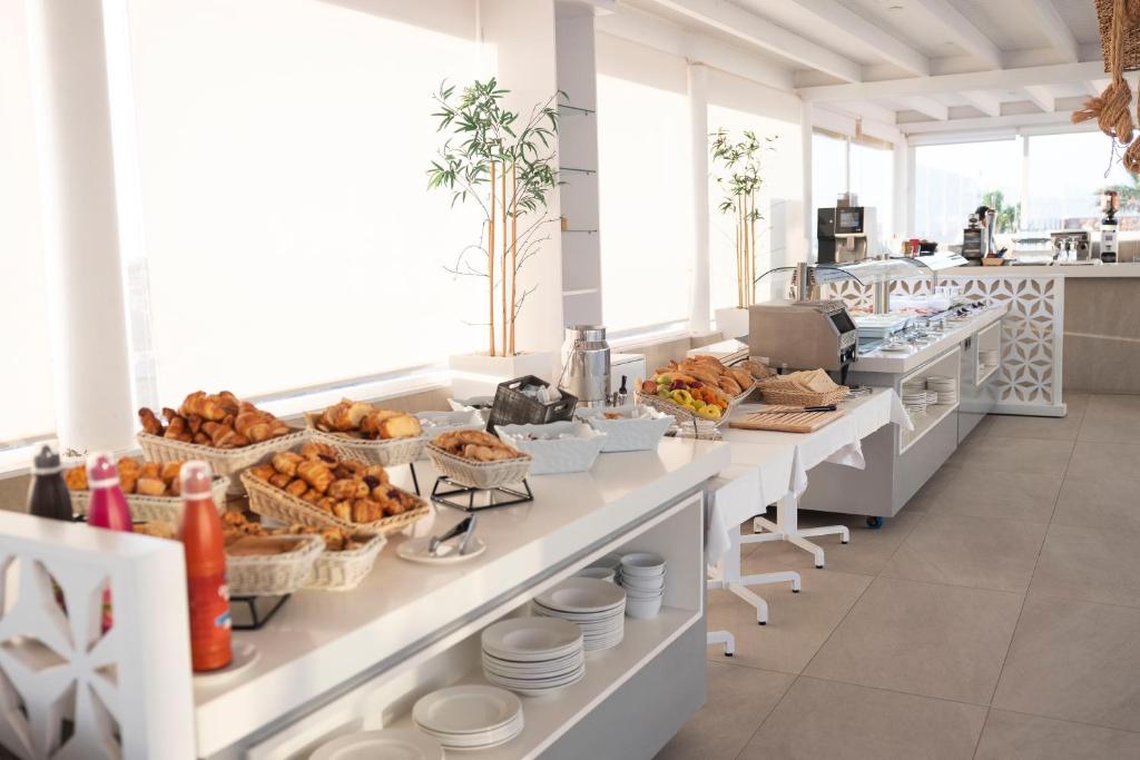 a buffet line with bread and other food items at Hotel Boutique TAO Caleta Mar in Corralejo