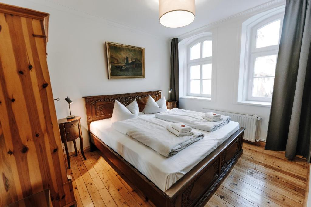 a bedroom with a large bed with white sheets and pillows at Apartments in der Blocksquerstraße in Lübeck