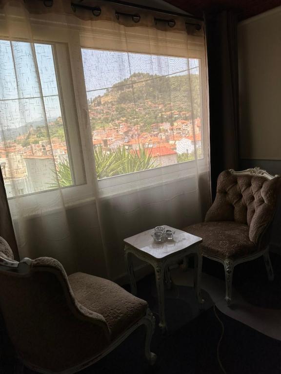 una camera con una sedia, un tavolo e una finestra di Με θέα το Κάστρο a Nafpaktos