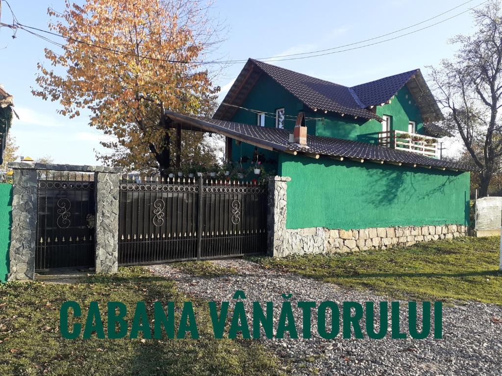 a house with a gate in front of it at Cabana Vanatorului 
