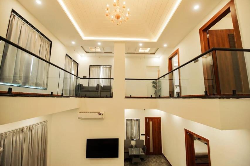 une pièce avec un salon avec une télévision et un escalier dans l'établissement Sunrise Villa Udaipur, à Udaipur