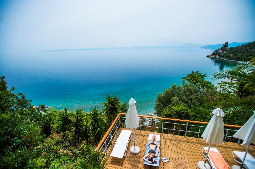 eine Frau auf einer Terrasse mit Meerblick in der Unterkunft Miradouro Sea Front Residences in Region Ilia