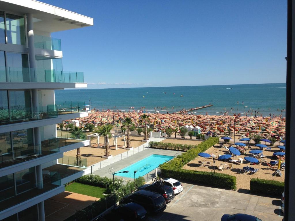 リド・ディ・イエゾロにあるHeron apartmentsのプールとビーチのあるリゾートの景色を望めます。