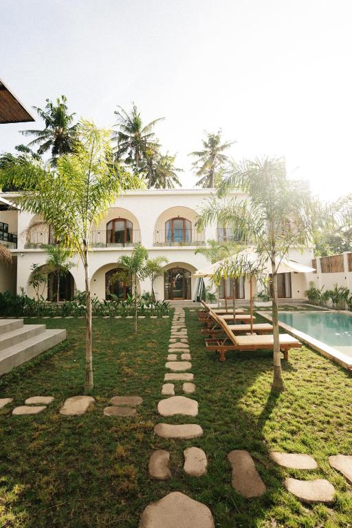 a house with a garden and a swimming pool at TWINFIN Surf House in Kuta Lombok