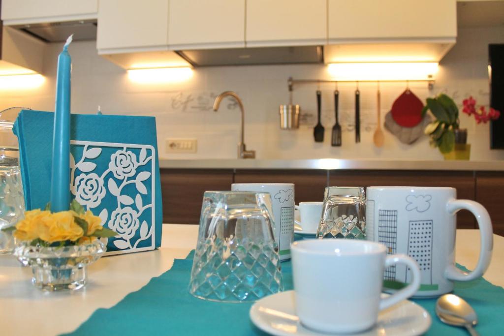 un tavolo con tazze e bicchieri su un bancone della cucina di La Casetta a Cefalù