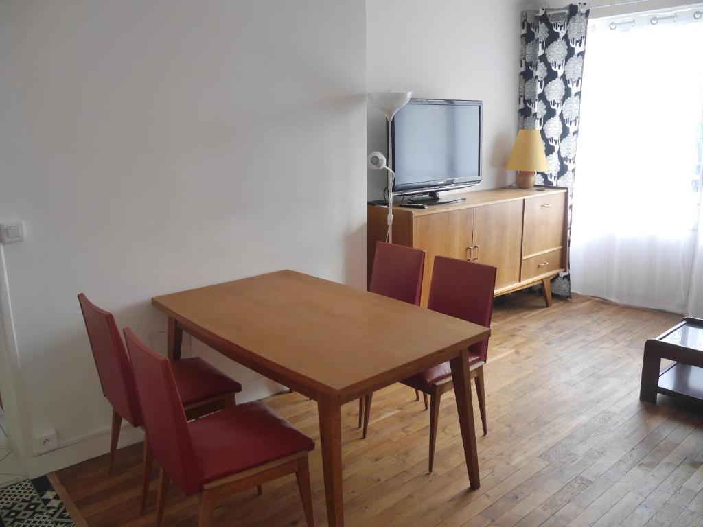 une salle à manger avec une table et des chaises et une télévision dans l'établissement Appartement 302, à Montreuil